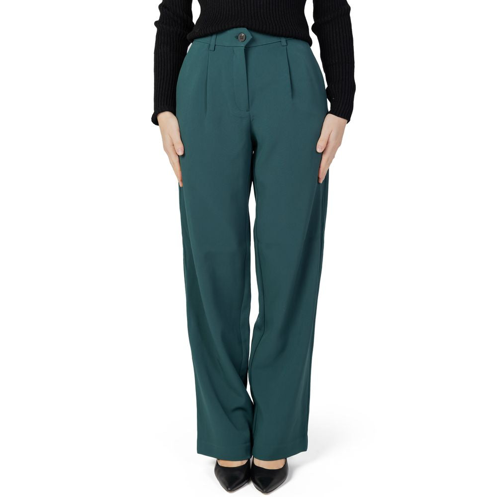 Woman wearing green bootcut pants made of recycled polyester for autumn winter collection, eco-friendly fashion