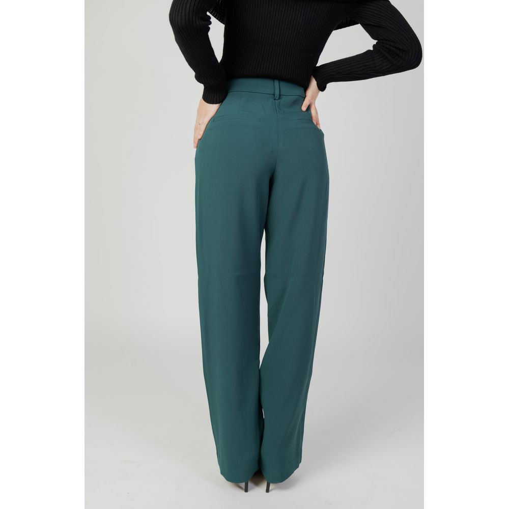 Woman wearing green bootcut pants made from recycled polyester, part of the autumn/winter collection from Vila Clothes.