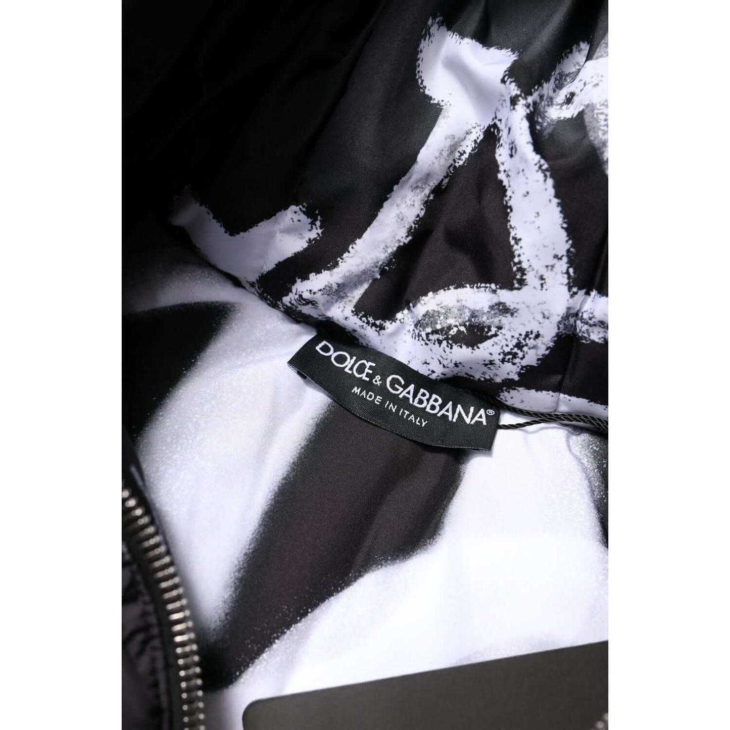 Close-up of Dolce & Gabbana label inside a black padded hooded jacket, showcasing the high-quality craftsmanship. Made in Italy.