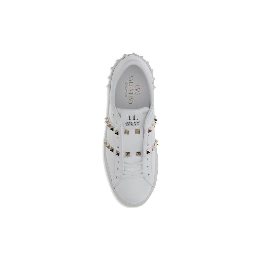 Valentino Garavani Rockstud Untitled SneakersValentino Garavani’s Rockstud Untitled Sneakers are a bold and refined interpretation of urban style. Crafted from white calfskin, they feature a platinum-finish studded appliqué band that lends a touch of shin