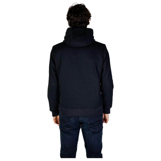 Back view of a person wearing a Hydra Clothing blue polyester jacket from the men's fall/winter collection.