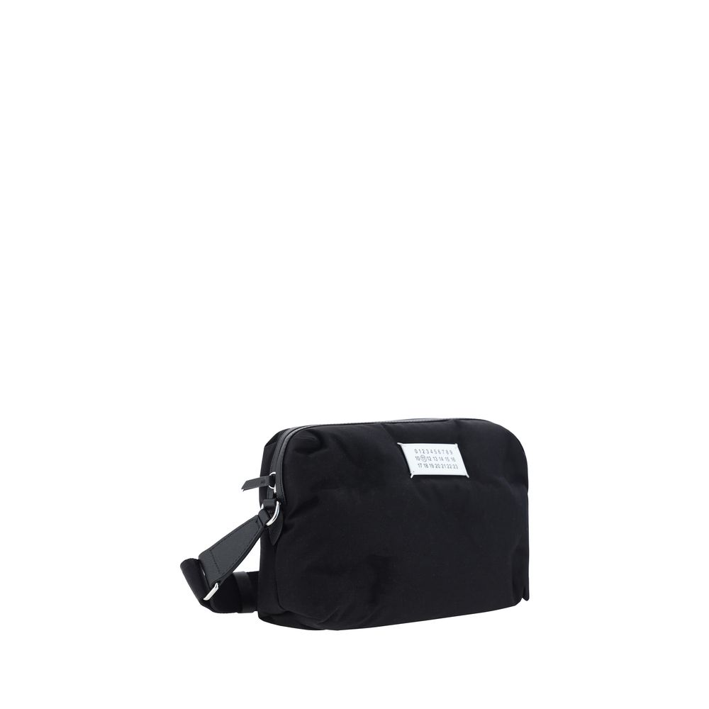 Margiela Black Nylon Shoulder Bag with calfskin leather inserts and logo label, featuring adjustable strap and zipper closure, AW25 season.