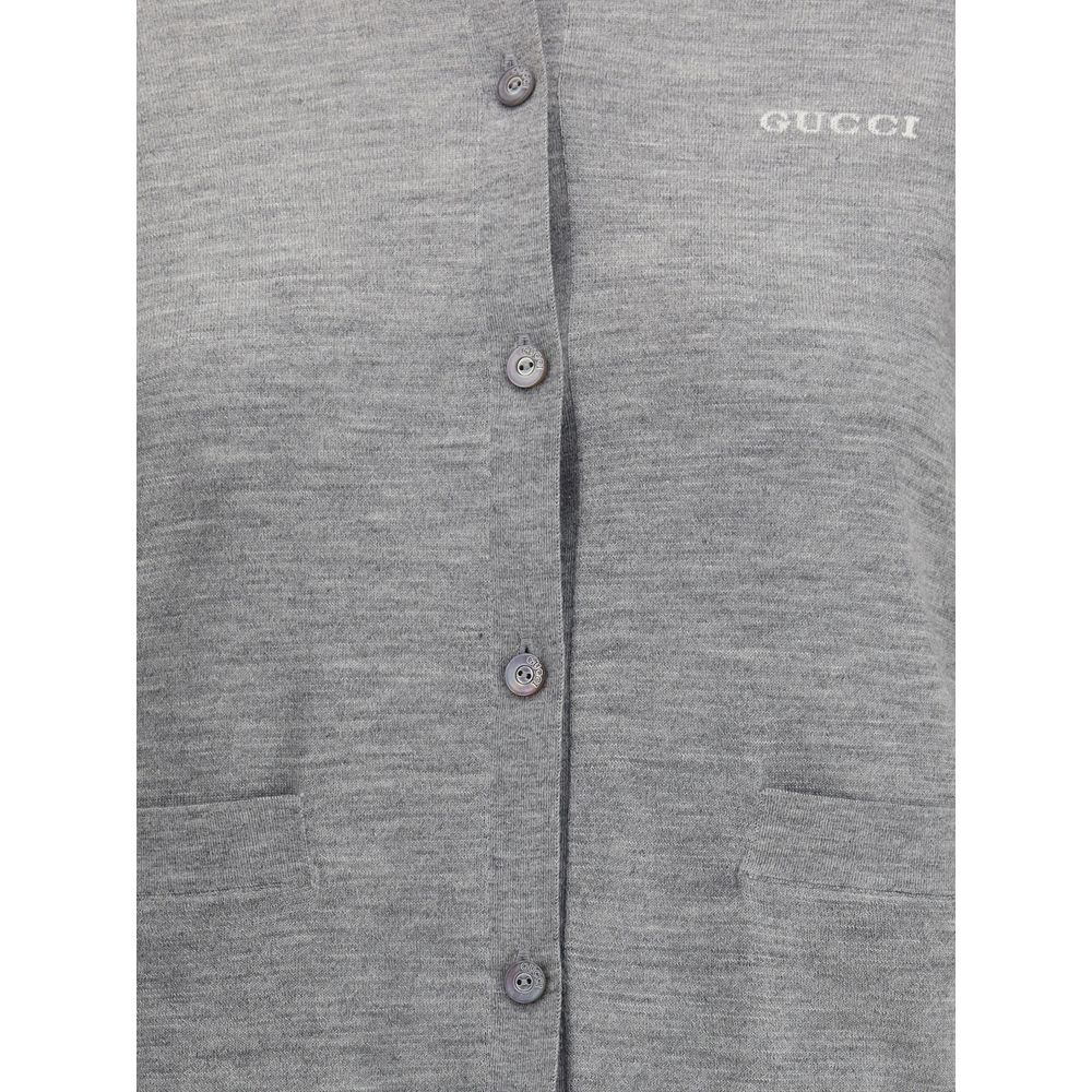 Close-up of Gucci Gray Cashmere Cardigan showing buttons and pockets, epitome of elegance and comfort with iconic stitched signature.