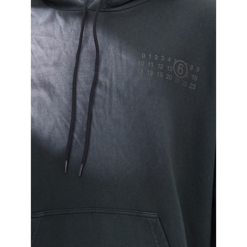 Close-up of MM6 Black Cotton Sweatshirt with logo, showcasing the kangaroo pocket and drawstring hood for a casual look.