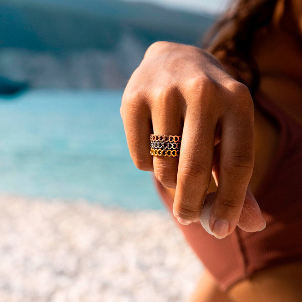 Hand wearing AN JEWELS JEWELRY Mod. AL.RSC01SYR-9 ring on a beach background.