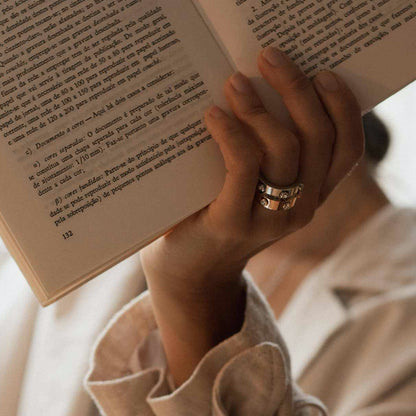 Person wearing AN JEWELS JEWELRY Mod. AL.RWH01SC-9 while reading a book, showcasing the intricate ring design.