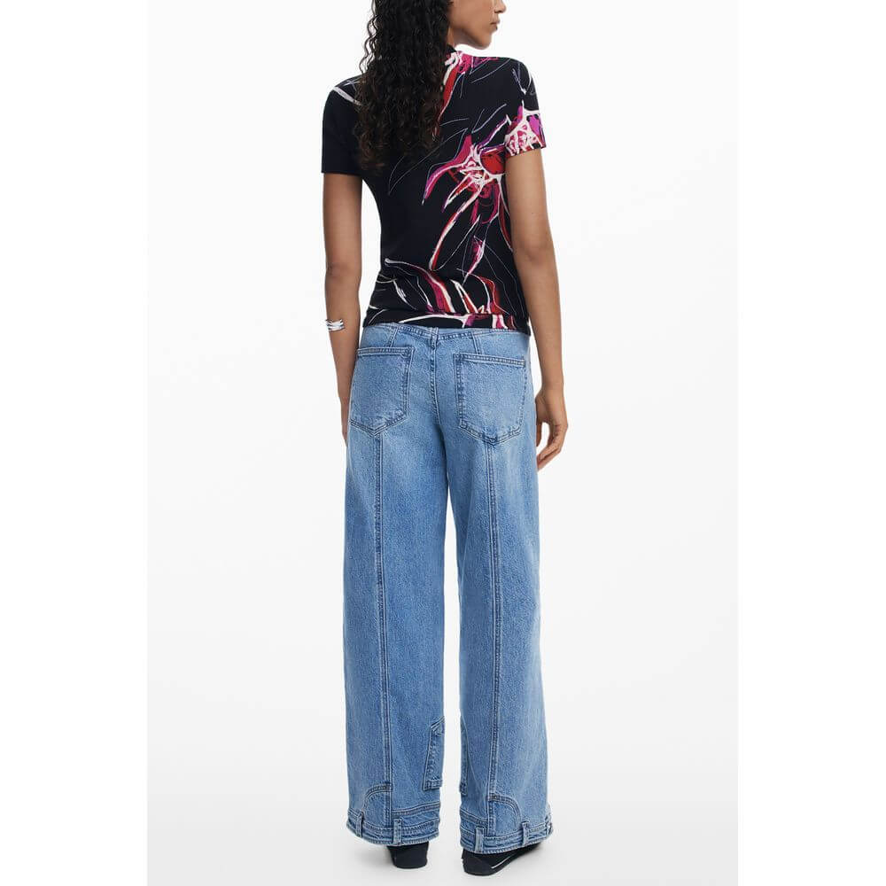 Back view of model wearing Desigual Black Viscose Women Top with signature print and blue jeans, showcasing bold and eclectic style.