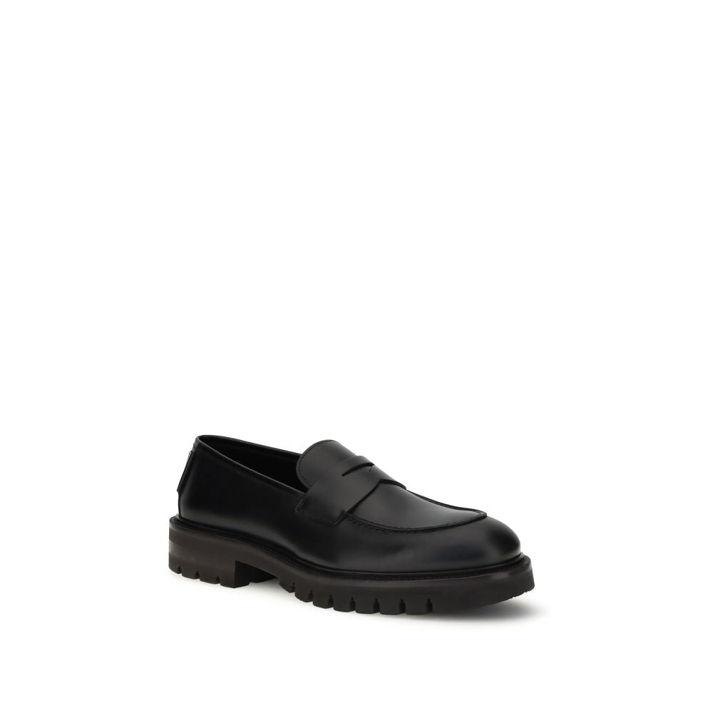 Ferragamo Black Rubber Slip-On Loafers with brushed calfskin upper and lug tread sole, offering elegant and modern design.