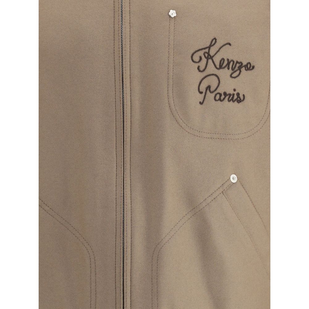 Close-up of Kenzo Brown Leather Jacket showing embroidered logo and pocket details on wool and leather fabric.