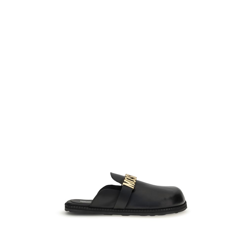 Moschino Black Calf Leather Bos Taurus Mules featuring golden logo plaque, rounded toe, ideal for versatile and stylish looks.