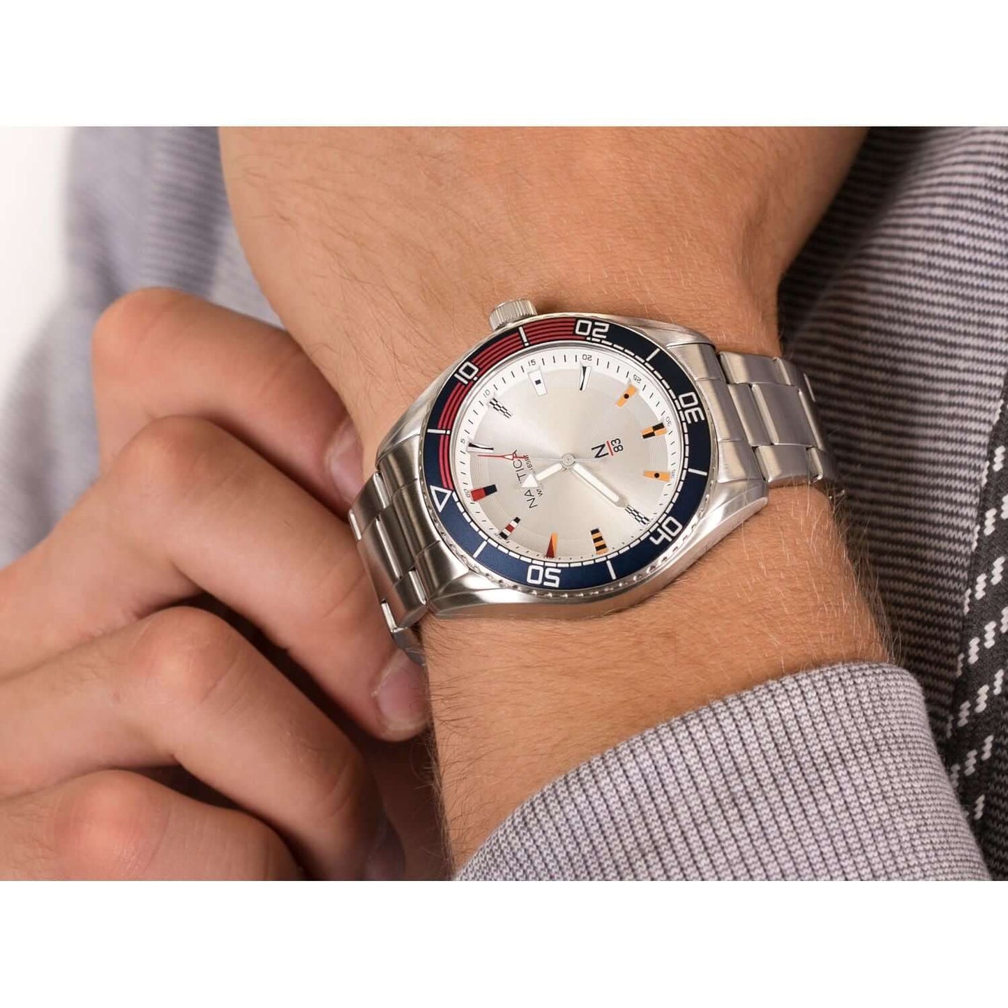 Gent's wrist wearing NAUTICA Mod. NAPFWS005, quartz analog, multifunction, water resistant watch, 44mm case, silver bracelet.