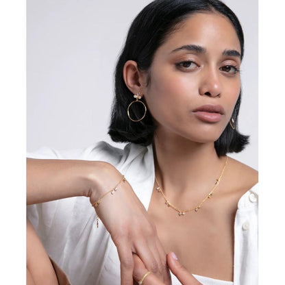 Model wearing Viceroy Jewels with gold bracelet and necklace set against a light background, highlighting elegant jewelry design.