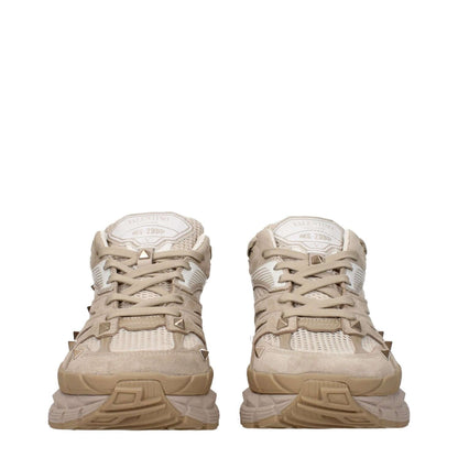 Valentino Garavani Beige Fabric Low Top Sneakers with studs, lace-up closure, and rubber sole. Front and back logos, mid heels, round toe.