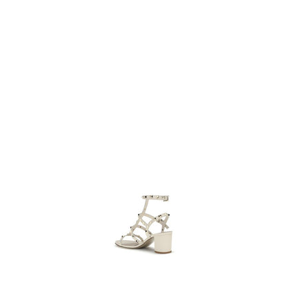 Valentino Garavani Cream Calf Leather Bos Taurus Sandals with Rockstud studs, round toe, adjustable ankle strap, and chunky heel.