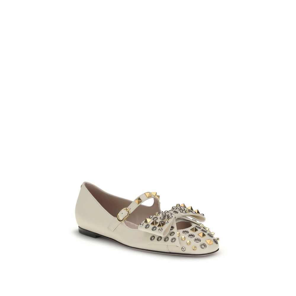 Valentino Garavani Cream Goatskin Ballet Flats with studs and bow detail, featuring adjustable buckle strap and antique-effect finish.