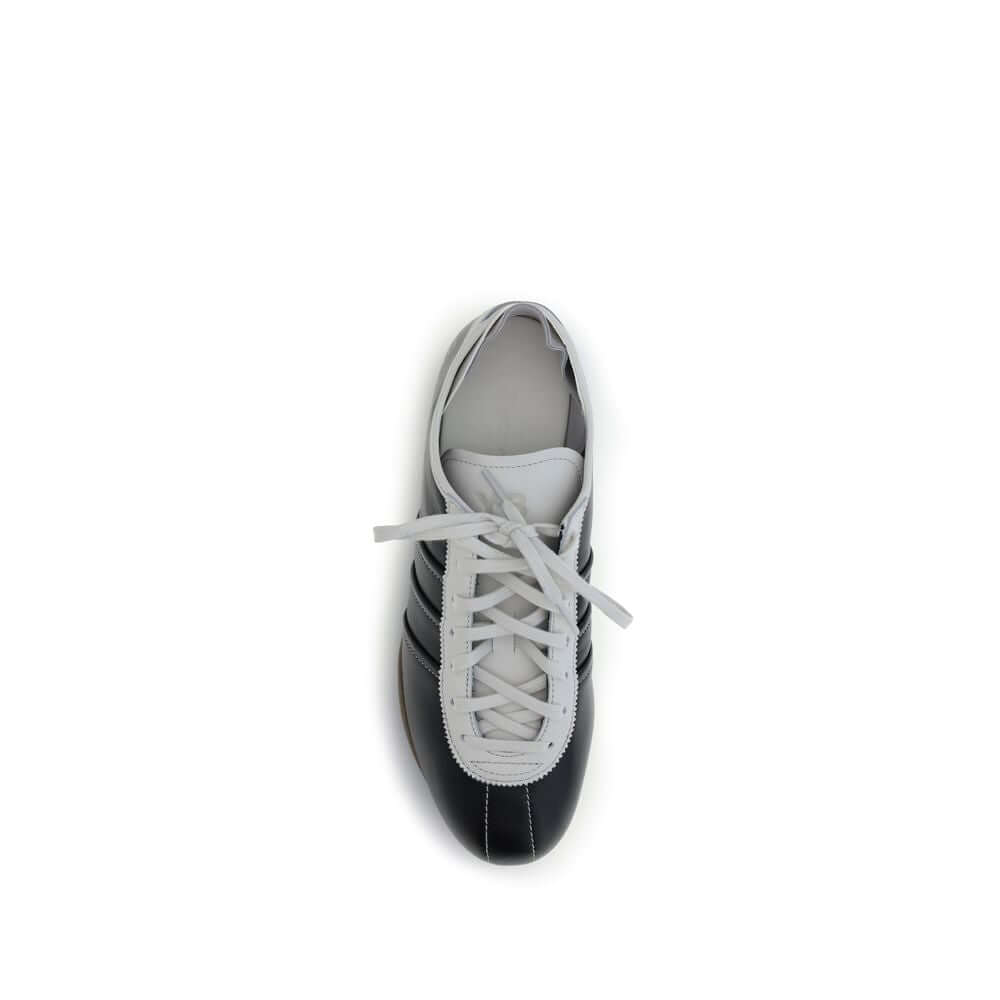Top view of Y-3 Black Calf Leather Bos Taurus Low Top Sneakers with white laces and striped detail, featuring a modern design.