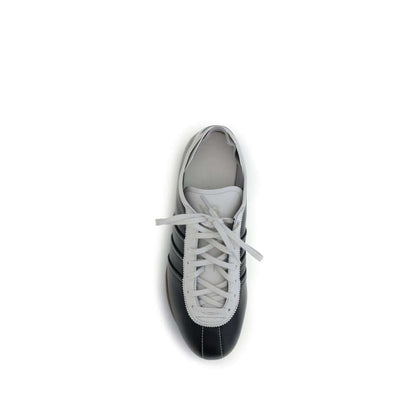 Top view of Y-3 Black Calf Leather Bos Taurus Low Top Sneakers with white laces and striped detail, featuring a modern design.